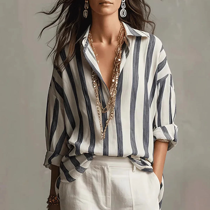 Women's blue and white striped relaxed fit button-down shirt. Versatile long sleeve top for casual or office wear.