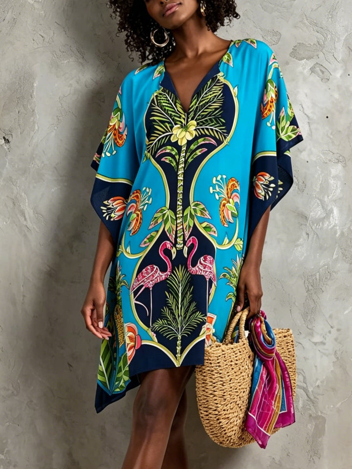 Women's blue tropical midi dress with V-neck, batwing sleeves, perfect for resort wear or summer vacation.
