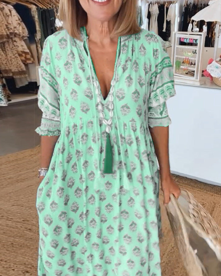 Comfortable women's bohemian midi dress. Features a V-neck, lantern sleeves, and essential pockets.