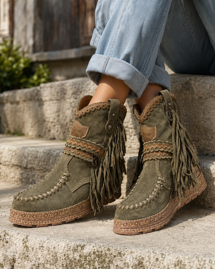 Brown women's western fringe ankle boots, slip-on style. Comfortable boho fashion footwear for travel and festivals.