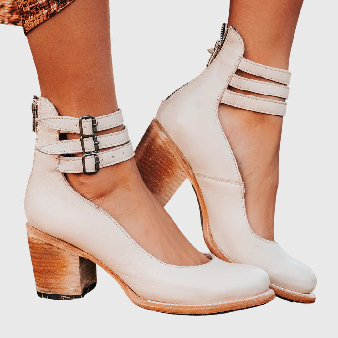 Black women's ankle boots with multiple bold buckle straps, side cutouts, and a sturdy block heel.