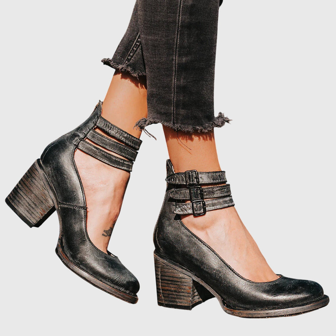 Modern women's ankle boots with bold buckle straps, stylish cutouts & block heel. Trendy casual footwear.