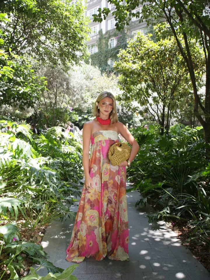 Fashionable women's strapless empire waist maxi dress in a bold floral print, a statement piece for events.