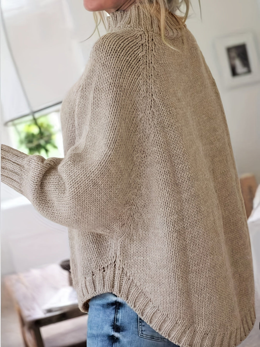 Trendy women's oversized cable knit sweater with a sophisticated high neck and graceful flared hem.
