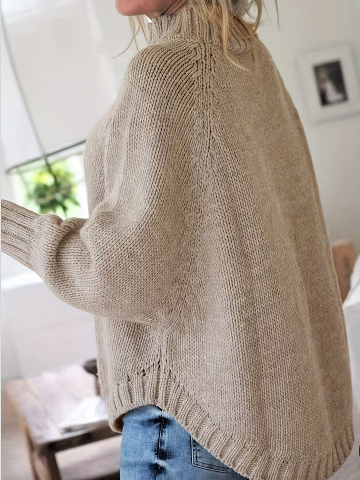 Trendy women's oversized cable knit sweater with a sophisticated high neck and graceful flared hem.
