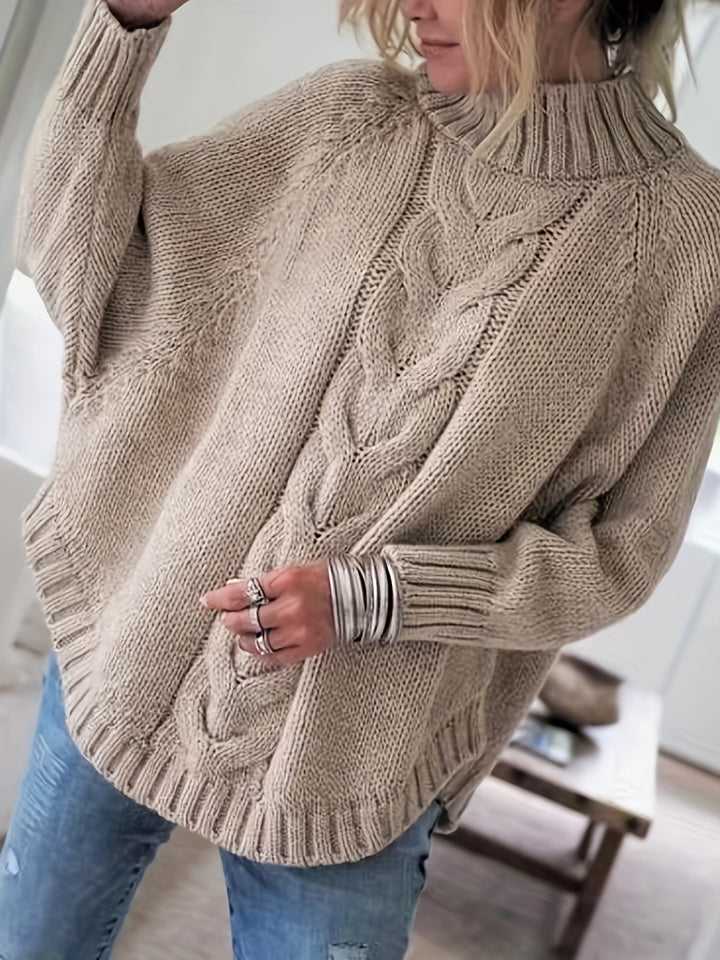 Warm batwing sleeve cable knit sweater for women, featuring a high neck and chic flared hem detail.