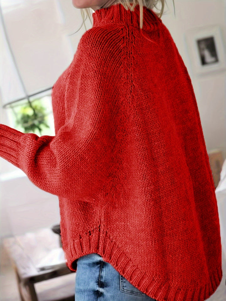 Soft cable knit women's sweater, high neck. Oversized fit with an elegant flared hem for winter fashion.
