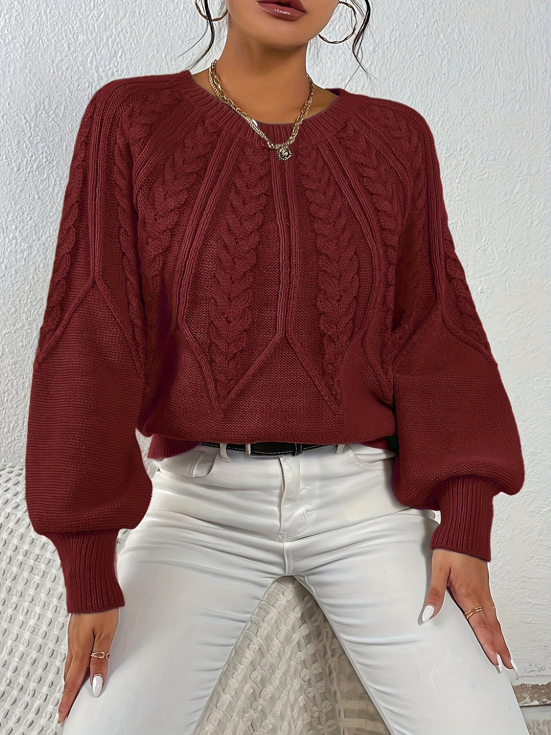 Front view of stylish women's cable knit pullover, relaxed fit, lantern sleeves.