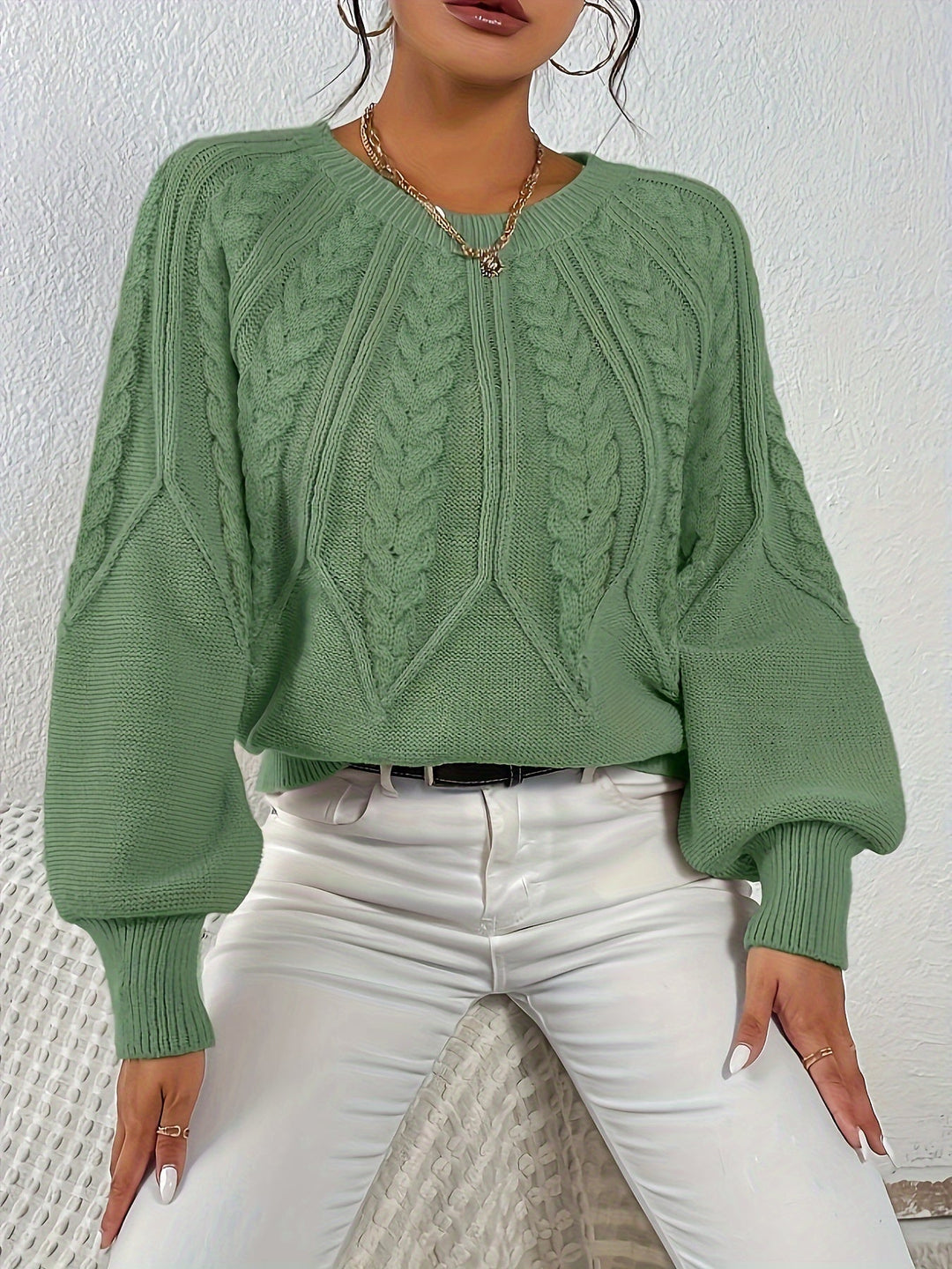 Stylish women's cable knit sweater with relaxed fit and chic lantern sleeves.