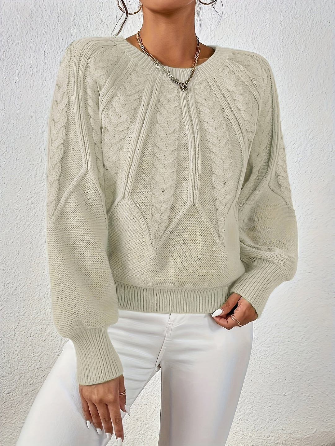 Chic women's cable knit sweater, relaxed fit, prominent lantern sleeves.