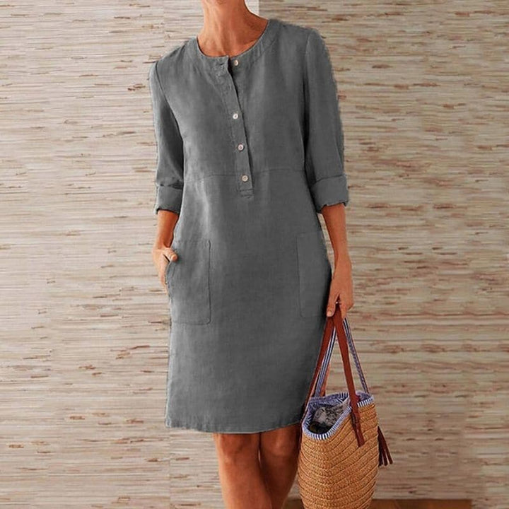 Relaxed fit women's button-front shift dress. Midi length with pockets, a comfortable and versatile casual dress.