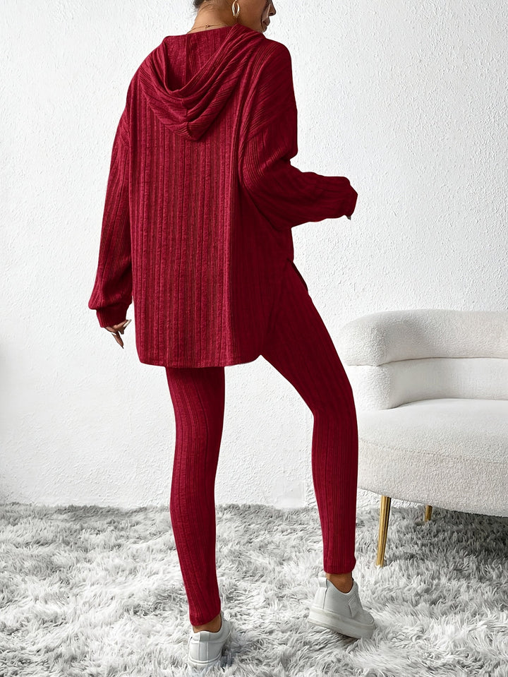 Model smiling, wearing a fashionable ribbed knit loungewear set; perfect for active and casual wear