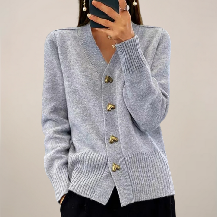 Elegant women's knit cardigan with gold heart buttons. Stylish long sleeve sweater for casual or workwear.
