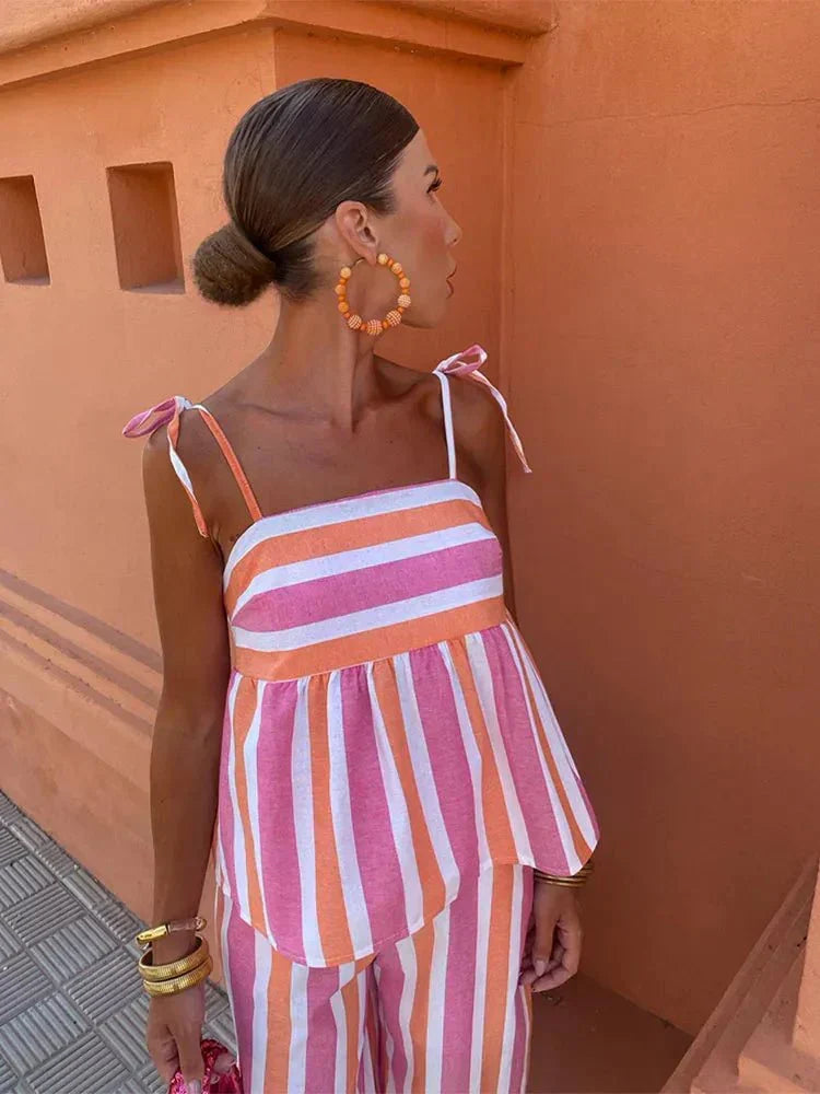 Modern striped women's outfit set with a flattering peplum top & fashionable wide leg trousers, versatile.