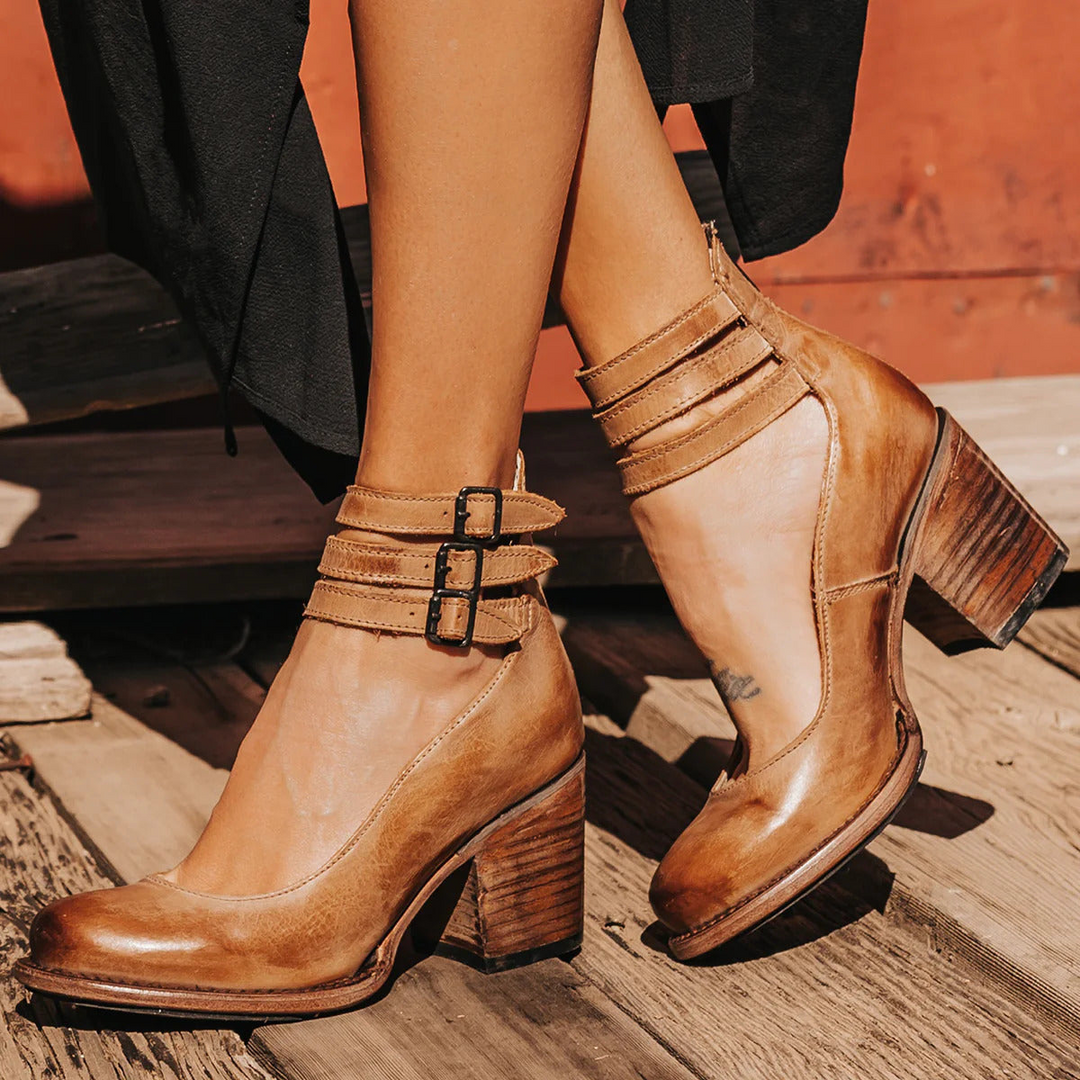 Elegant women's round toe pumps with a stylish block heel and secure ankle strap. Fashionable footwear.