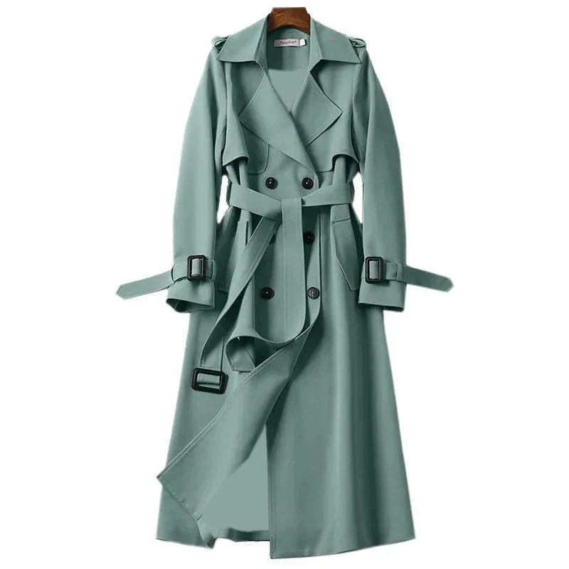 Classic women's long trench coat featuring double-breasted front, tie-waist & lapels. Elegant ladies' outerwear.