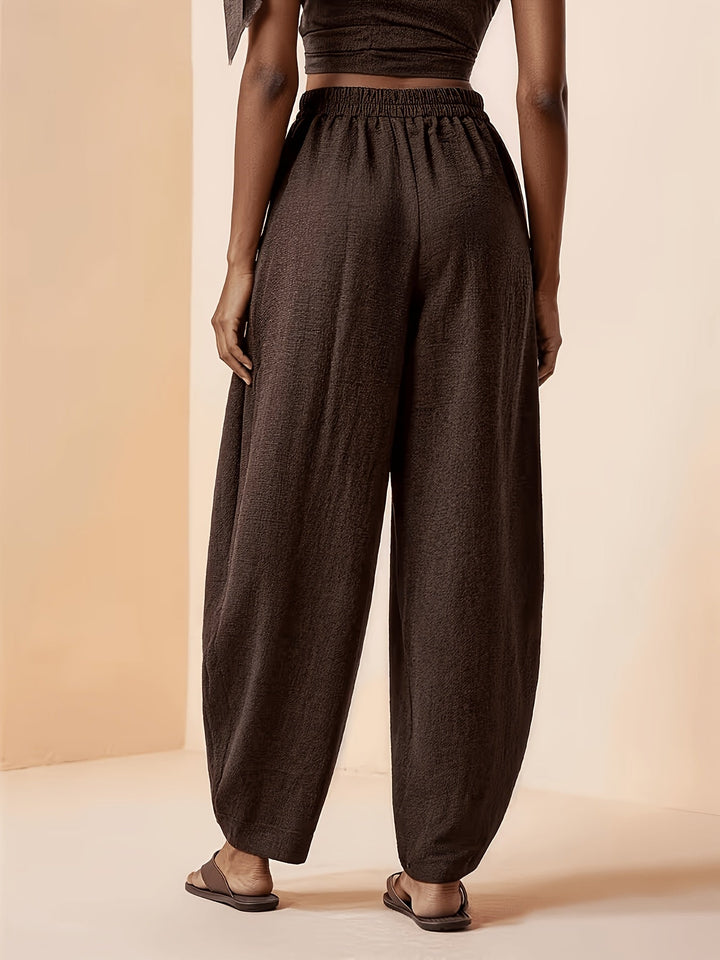 Chic women's coffee brown pleated high-waist harem pants with tapered ankle. Perfect for relaxed everyday style.