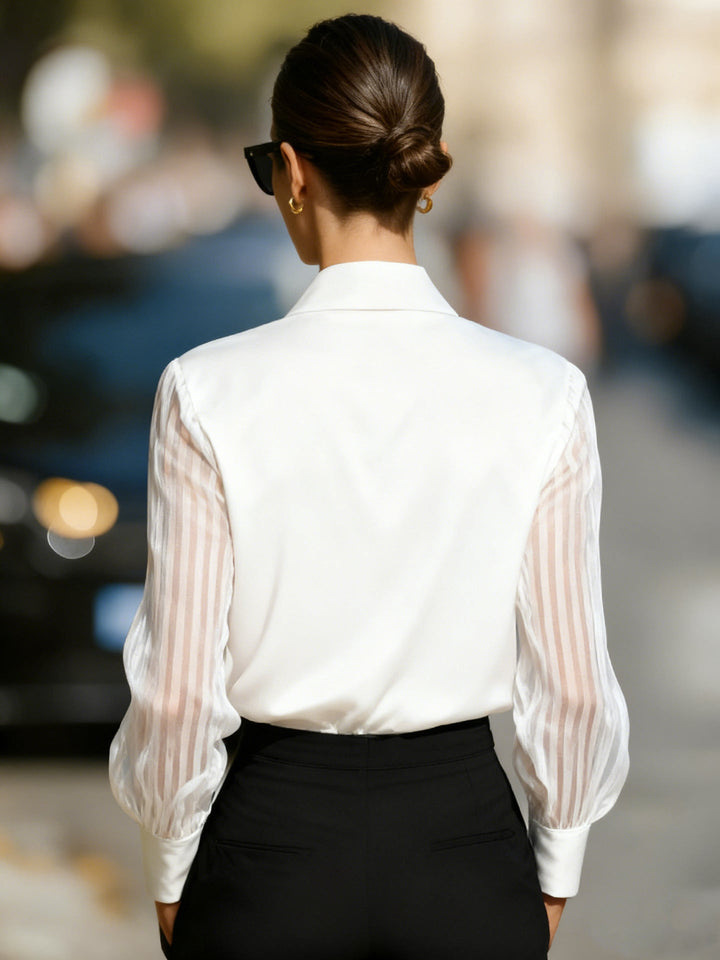 Textured view of a women's professional collared blouse, highlighting the elegant sheer long sleeves.