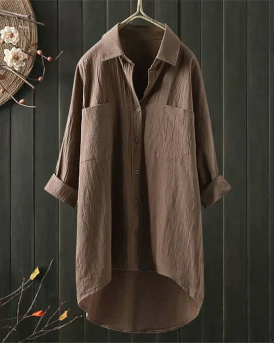 Stylish women's collared button-down blouse, featuring double pockets & roll-tab sleeves. Chic longline summer top.