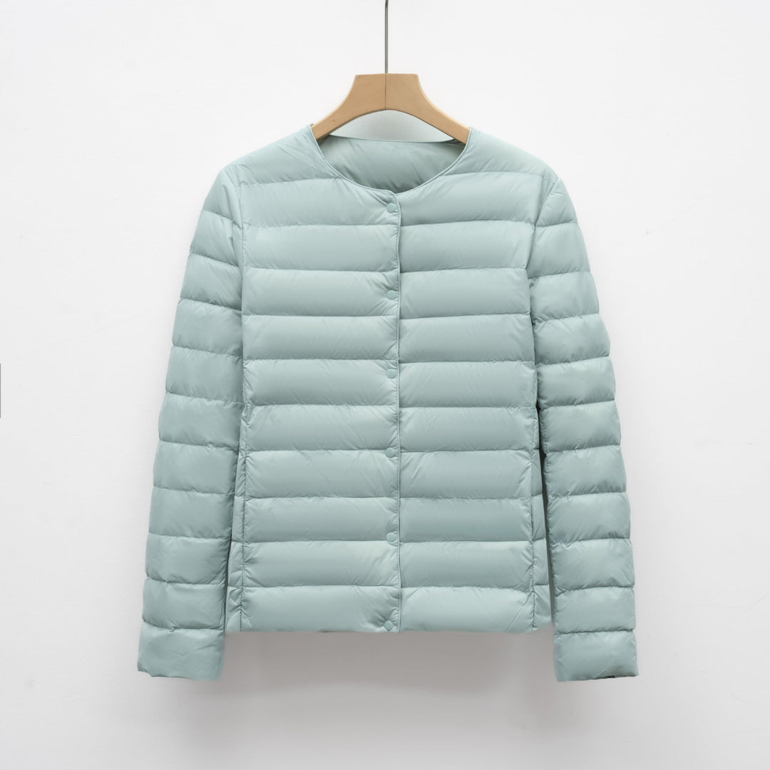 Minimalist women's collarless puffer jacket in white, an ultralight and packable outerwear option for all seasons.