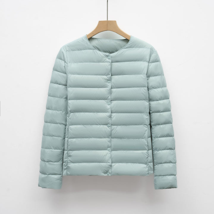 Minimalist women's collarless puffer jacket in white, an ultralight and packable outerwear option for all seasons.