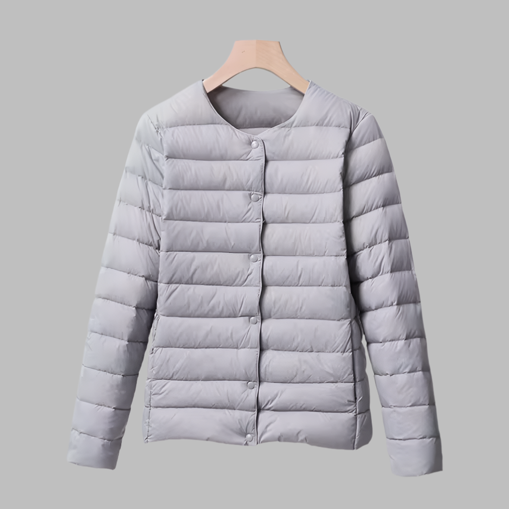 Stylish women's ultralight puffer jacket, collarless for easy layering, in a versatile gray, perfect travel companion.