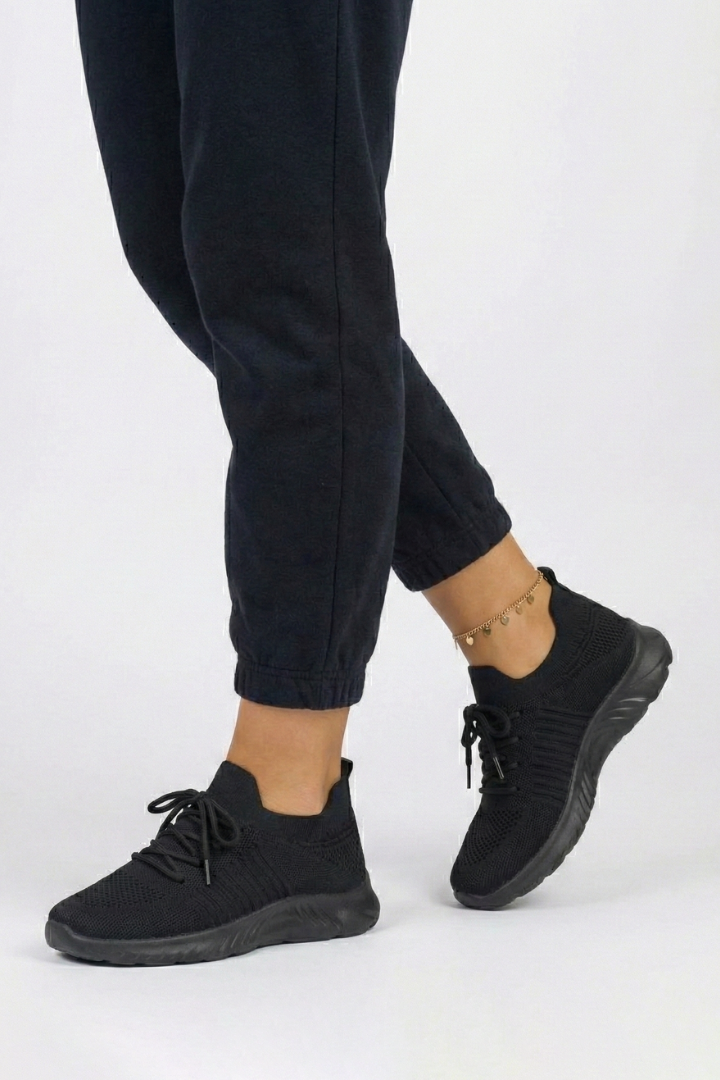 Stylish women's knit sneakers with secure laces, low silhouette & textured sole for athletic comfort.