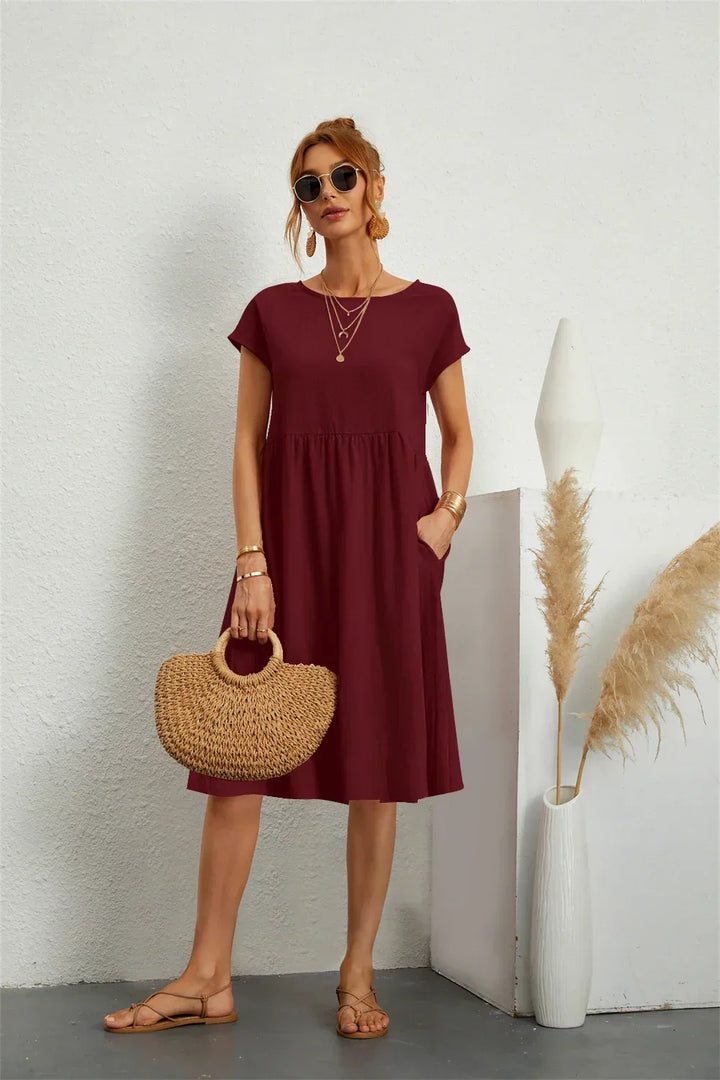 Versatile women's relaxed fit midi dress with pockets, offering comfortable and chic casual wear.
