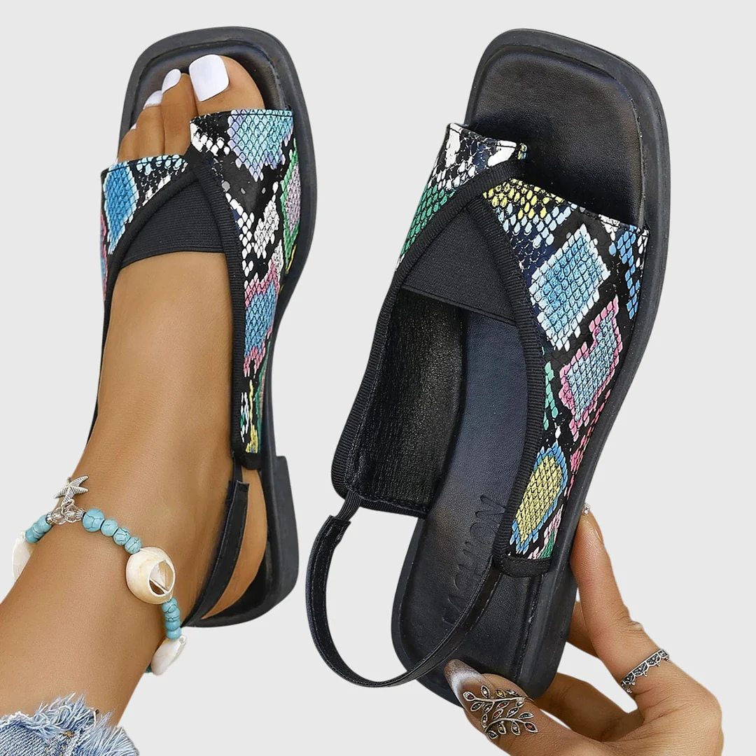 Vibrant orange women's orthopedic summer sandals. Comfortable flat slip-on shoes, ideal for casual beachwear and sunny days.