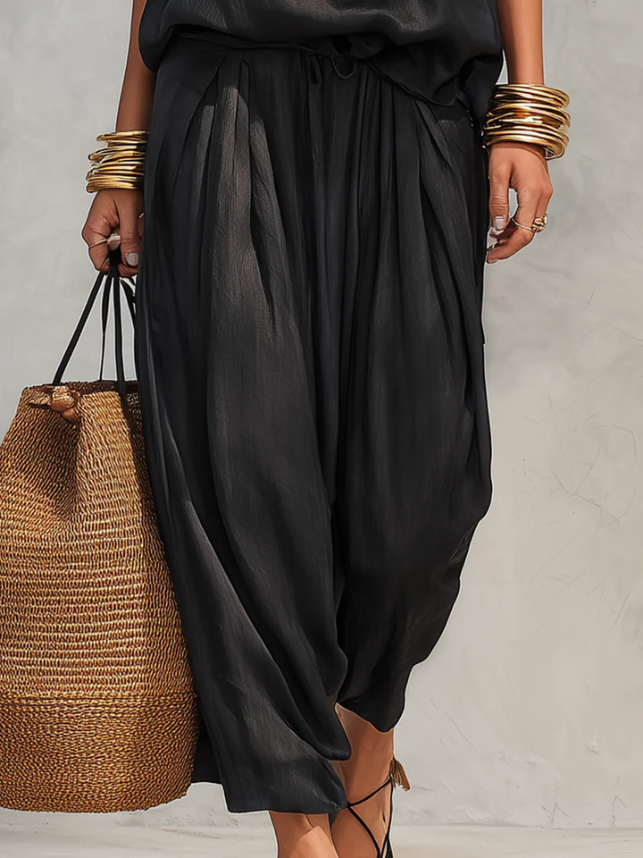 Stylish women's cowl neck halter top and wide leg pant set. Versatile resortwear or elegant party outfit.