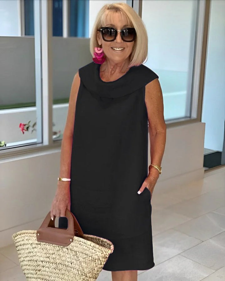 Comfortable women's sleeveless cowl neck shift dress. Features convenient pockets & a relaxed, flowy fit for everyday style.
