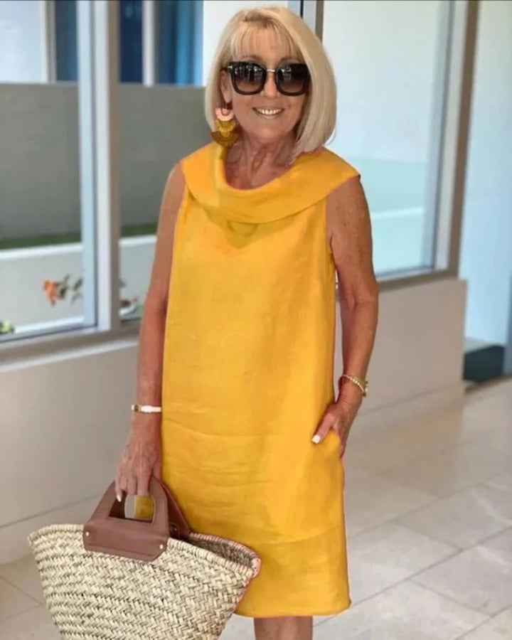 Elegant yet casual women's cowl neck shift dress. Sleeveless, relaxed fit, and pockets make it ideal for any summer day.