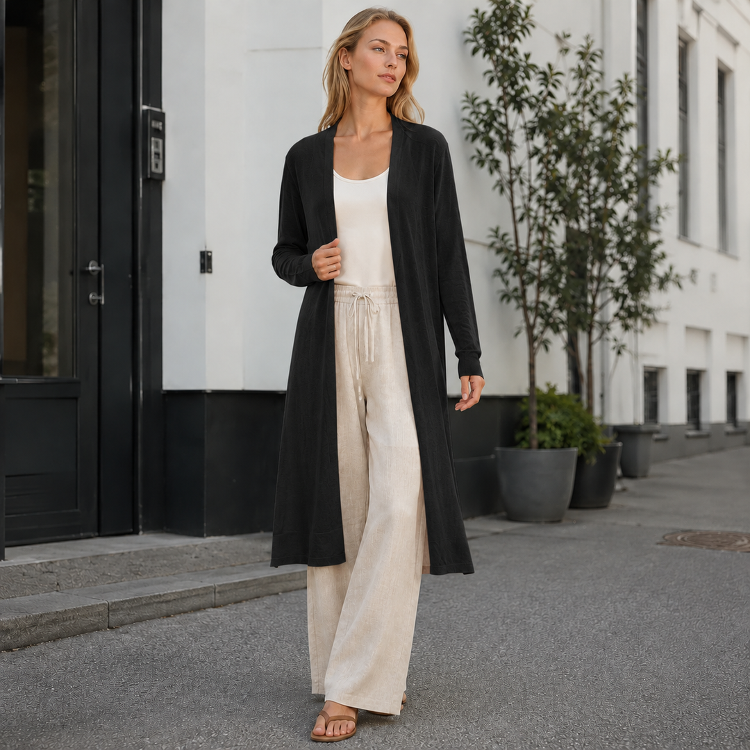 Back view of a flowing women's long knit cardigan, showcasing its elegant length & silhouette.