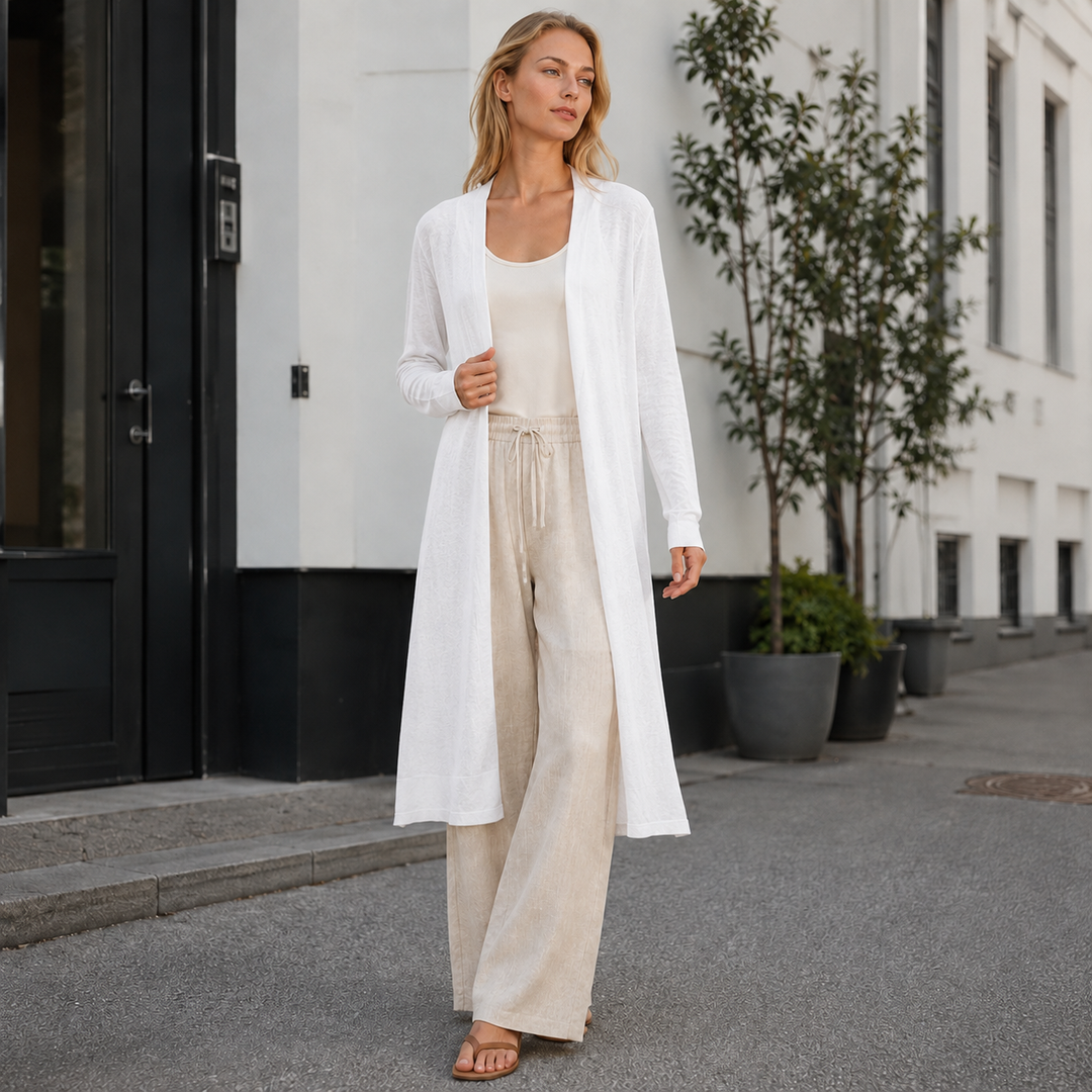 Happy woman in a comfy long knit cardigan, demonstrating cozy fall and winter fashion.