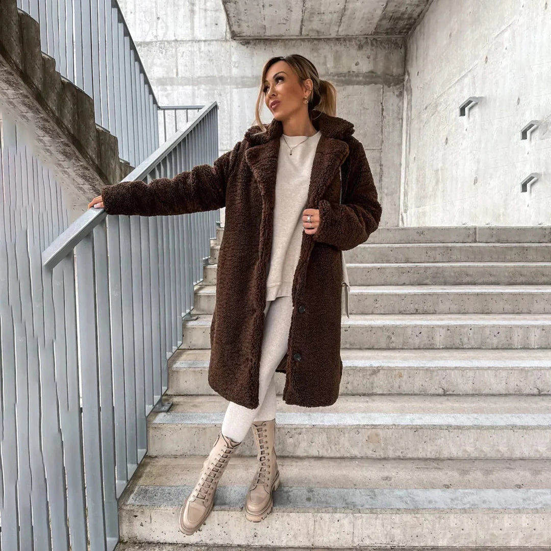 Stylish women's longline teddy coat in a cozy, warm fabric, ideal for winter outerwear. Features a button closure.