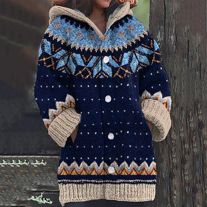 Close-up of a women's hooded knit cardigan featuring a beautiful Nordic Fair Isle pattern in warm winter tones.
