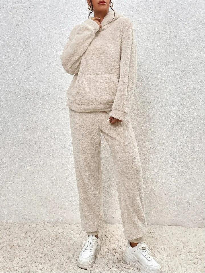 Woman enjoying ultimate comfort in a two-piece plush hooded loungewear set, ideal for relaxation.