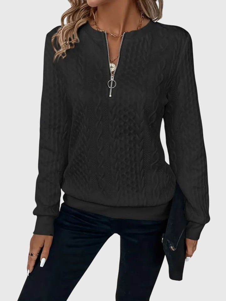 Warm women's chunky cable knit quarter-zip sweater, a cozy essential for winter fashion.