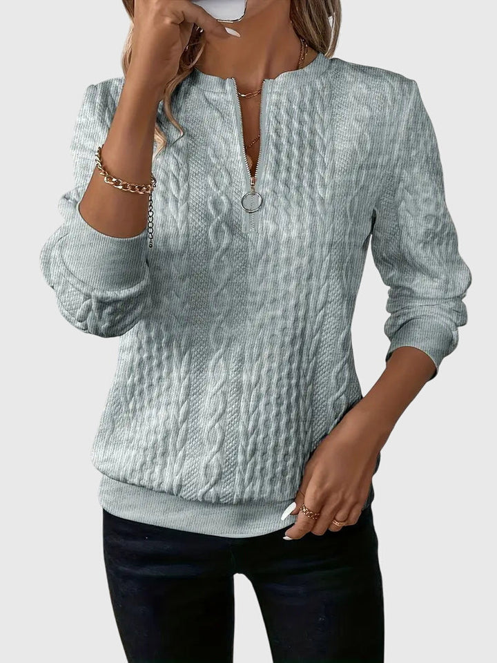 Women's seasonal cable knit quarter-zip pullover, great for layering in cooler weather.