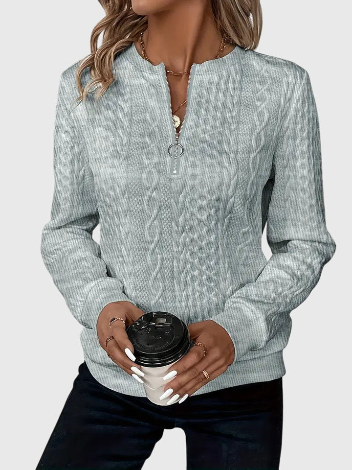 Durable women's cable knit pullover, quarter-zip, offers warmth and timeless style.