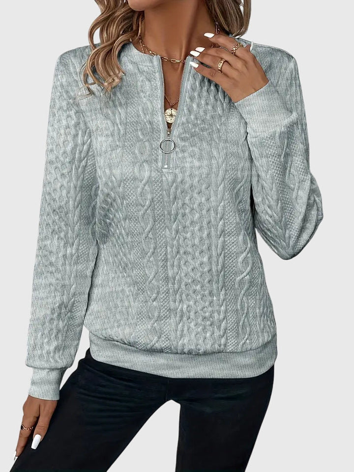 Women's vintage-inspired cable knit quarter-zip sweater, a cozy winter wardrobe staple.