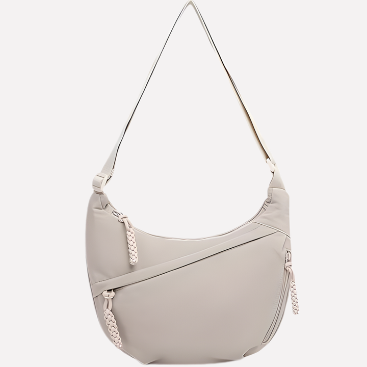 Modern women's crescent crossbody bag with sophisticated braided handle. Fashion accessory.