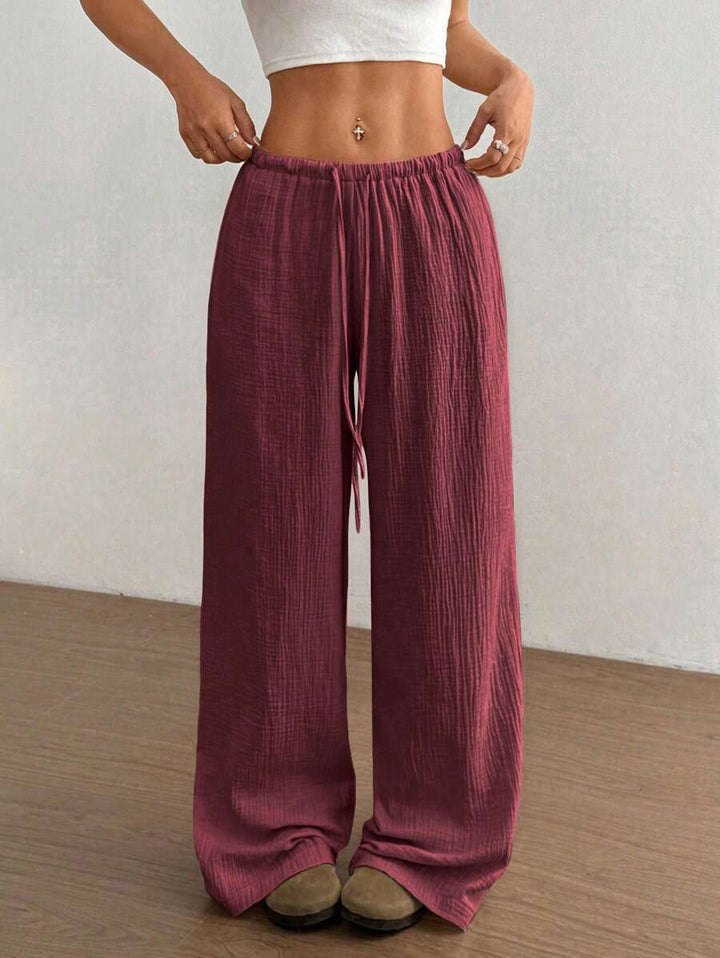 Flowy bohemian crinkle wide leg pants for women, featuring an adjustable drawstring waist.