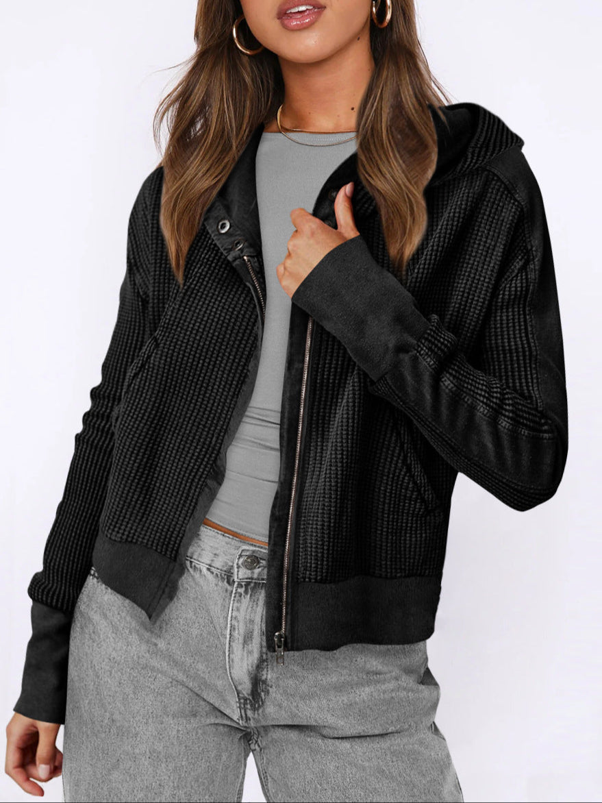 Woman reaching for her women's cropped waffle-knit zip hoodie, ready for comfort