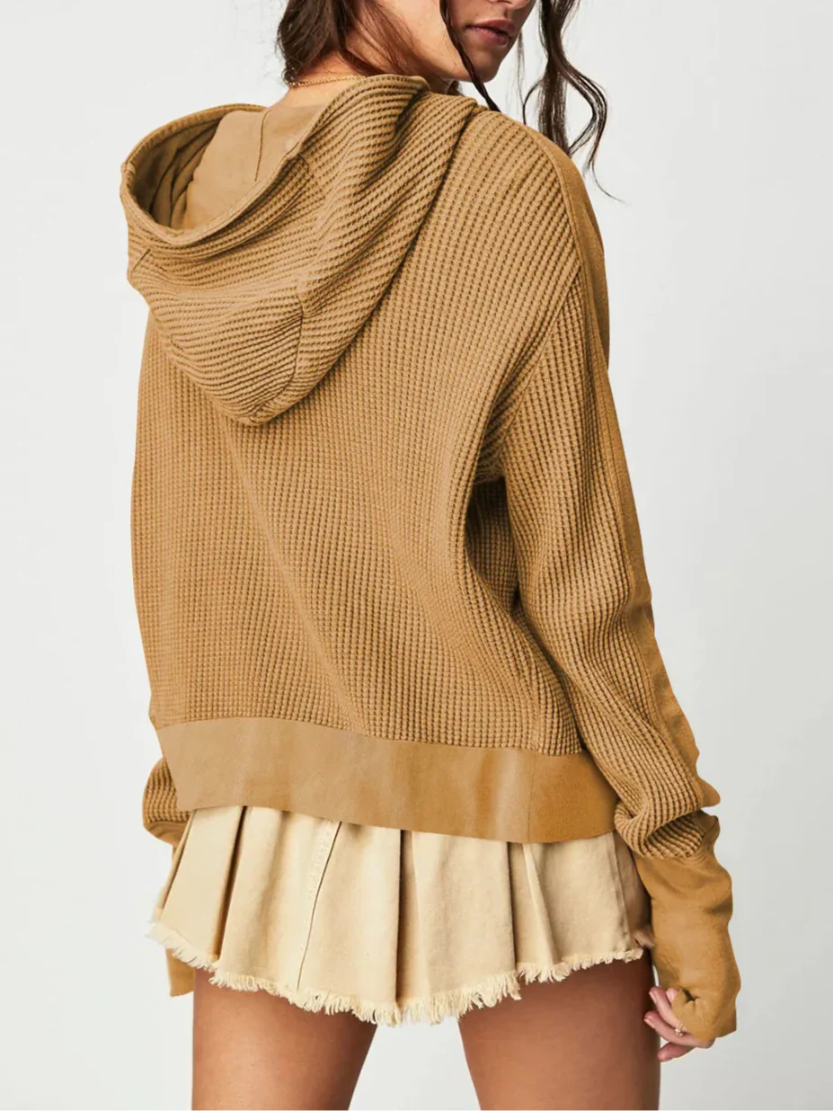 Close-up of the front pockets on a women's cropped waffle-knit zip hoodie, functional