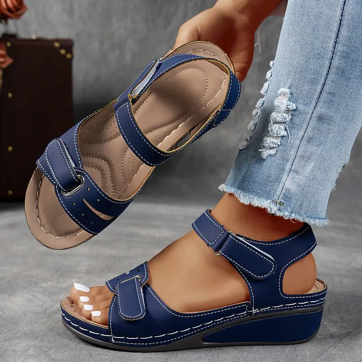 Soft cushioned women's wedge sandals with secure adjustable strap, offering ergonomic support for feet.