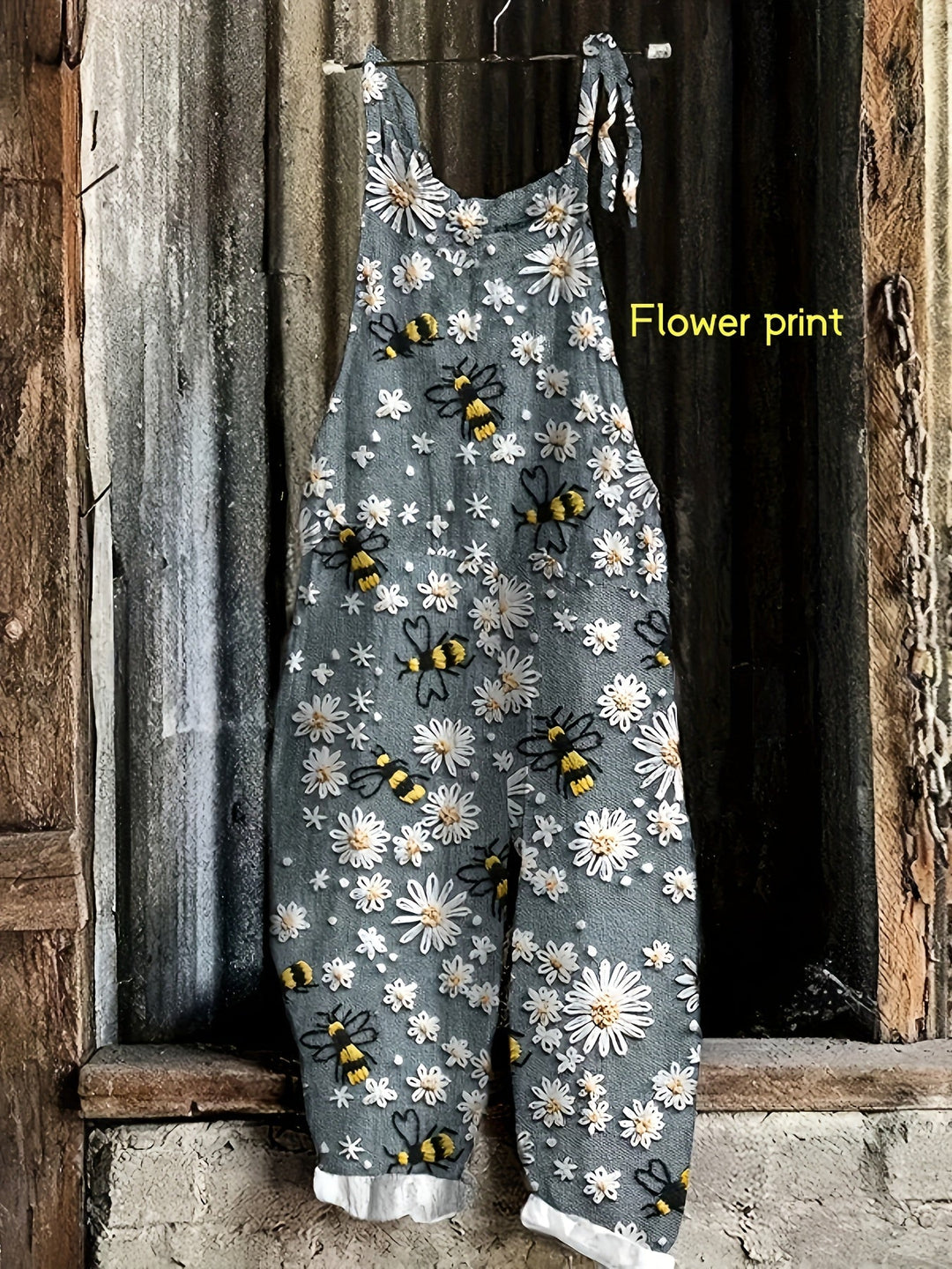 Women's tie-shoulder jumpsuit with pockets, showcasing a vibrant daisy bee print and wide legs.