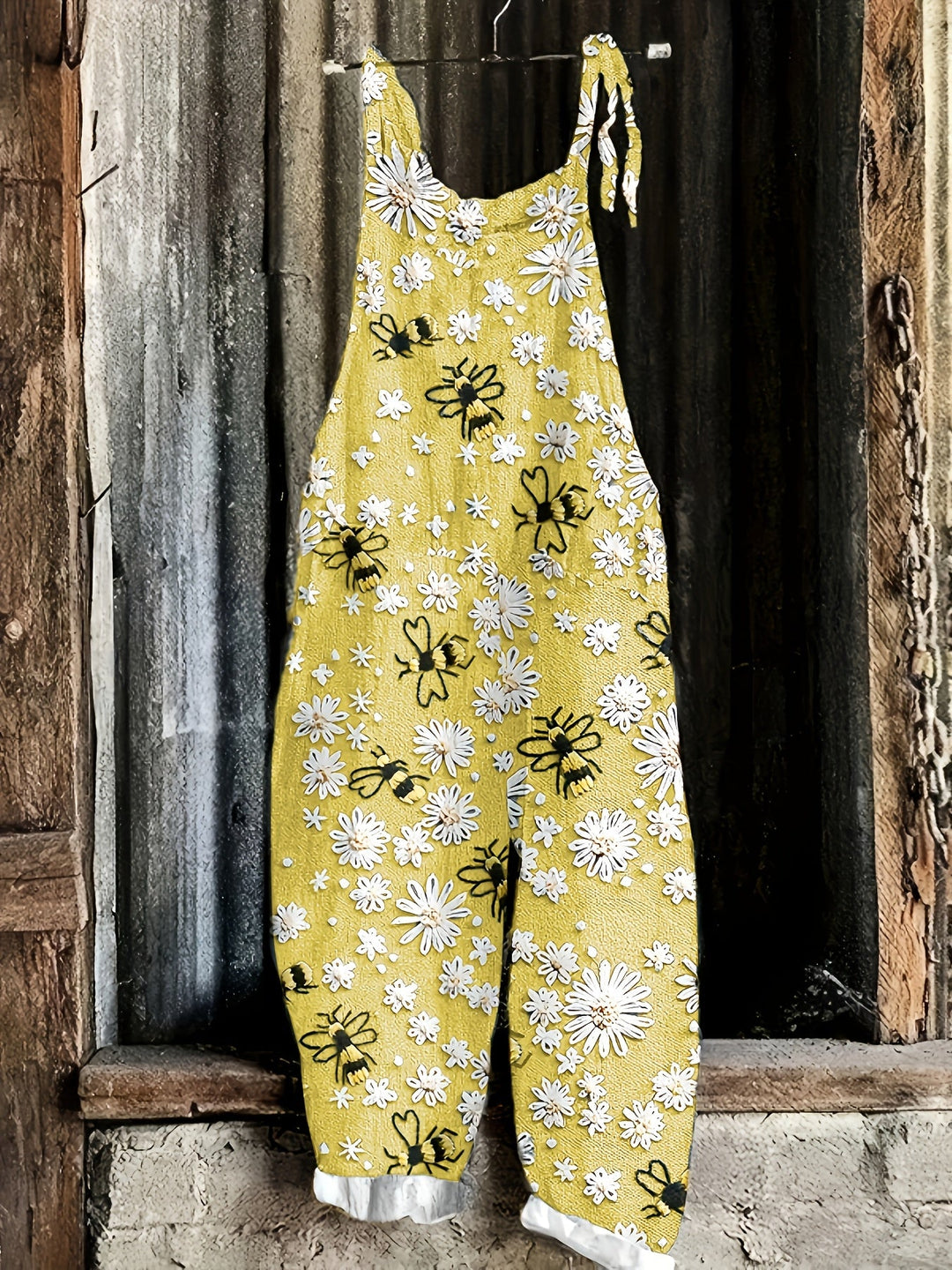 Women's tie-shoulder jumpsuit with a delightful daisy bee motif, practical pockets, and a stylish wide leg.