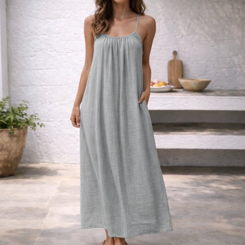 Elegant women's summer maxi sundress with flowing design, spaghetti straps & pockets for effortless style.