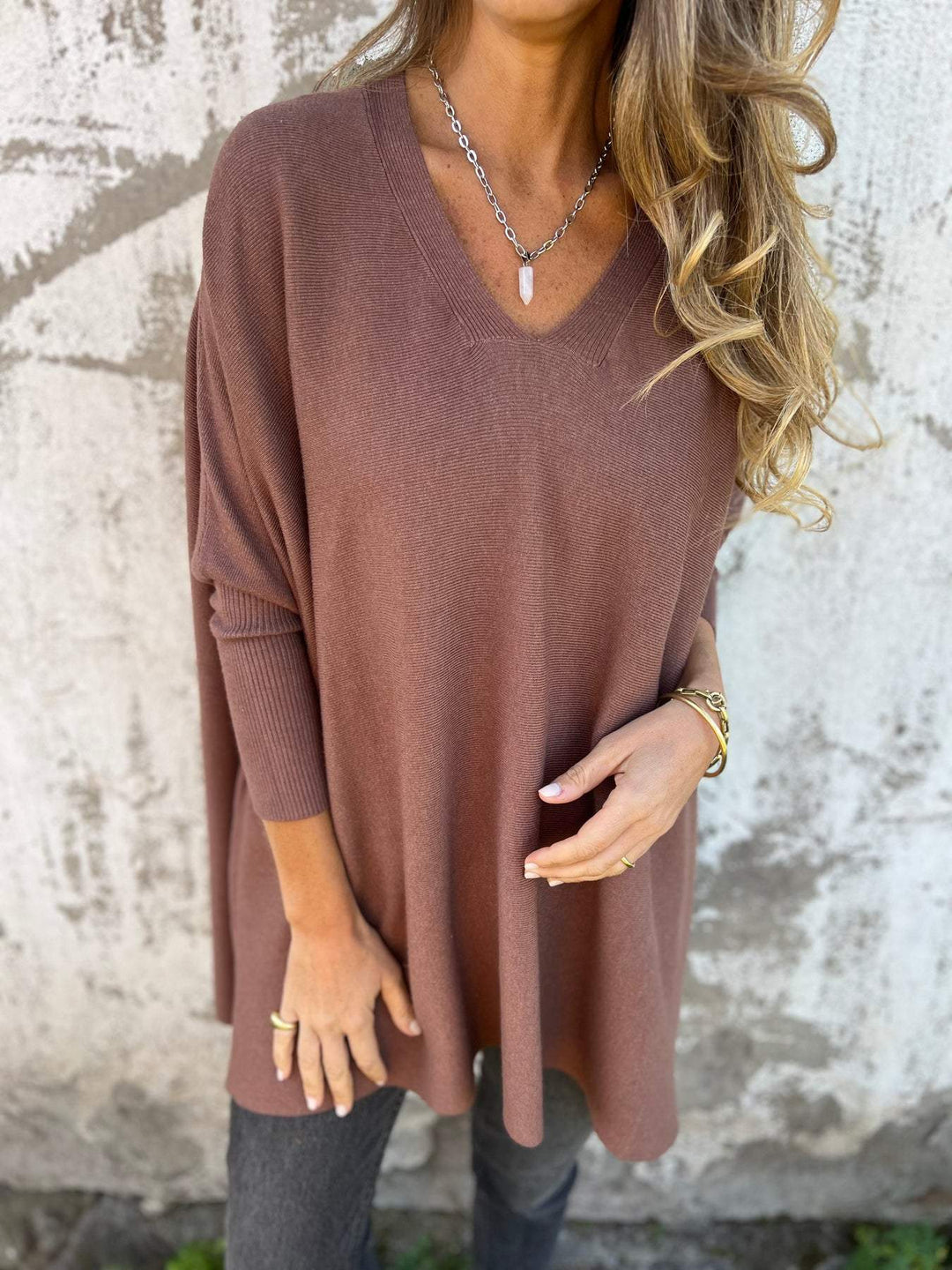 Close-up of a women's V-neck pullover sweater, showing soft knit fabric and relaxed neckline. Ideal for comfort.